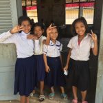 Photograph of four girls smiling, Cambodia