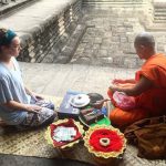 Woman sitting with monk, Cambodia